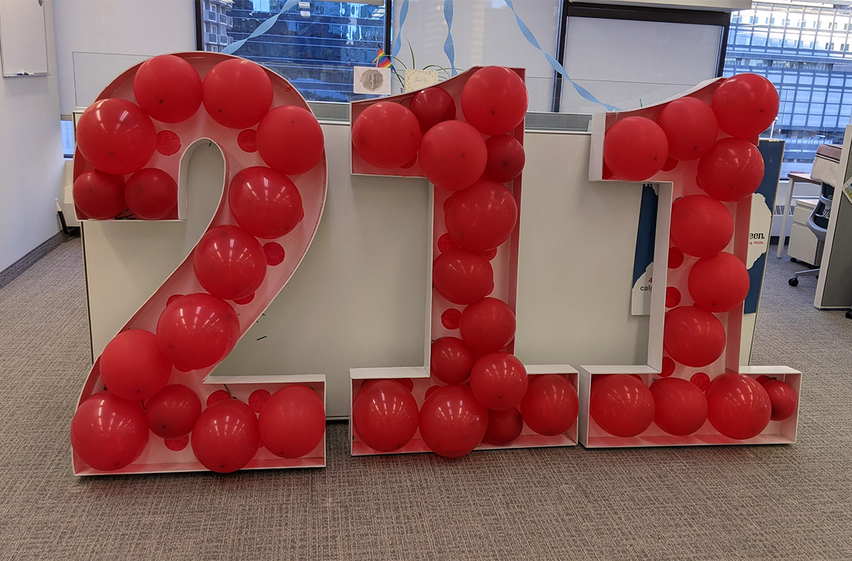 img des: large numbers spelling '211,' filled with red balloons